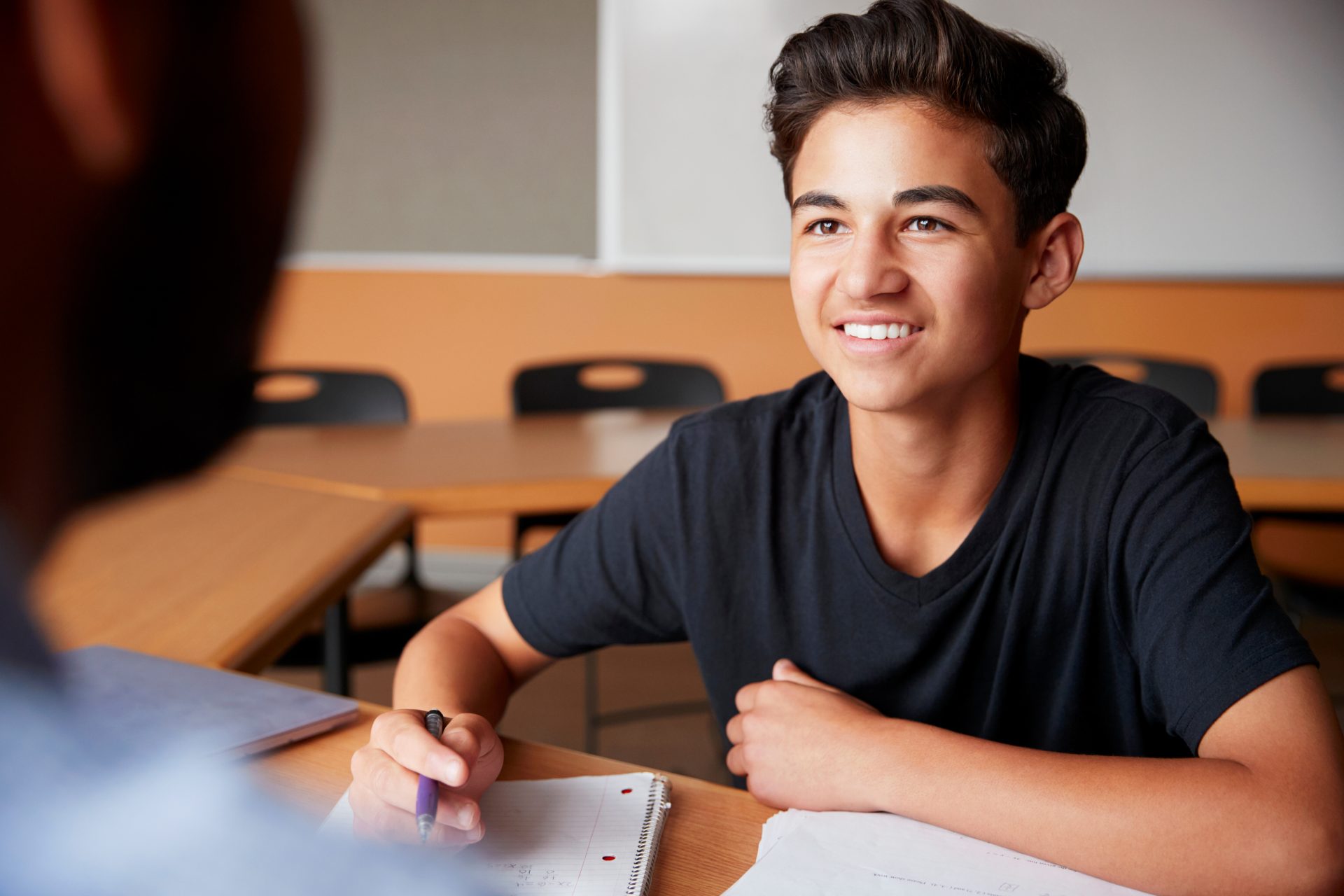 Hispanic student taking notes in class Hispanic student taking notes in class