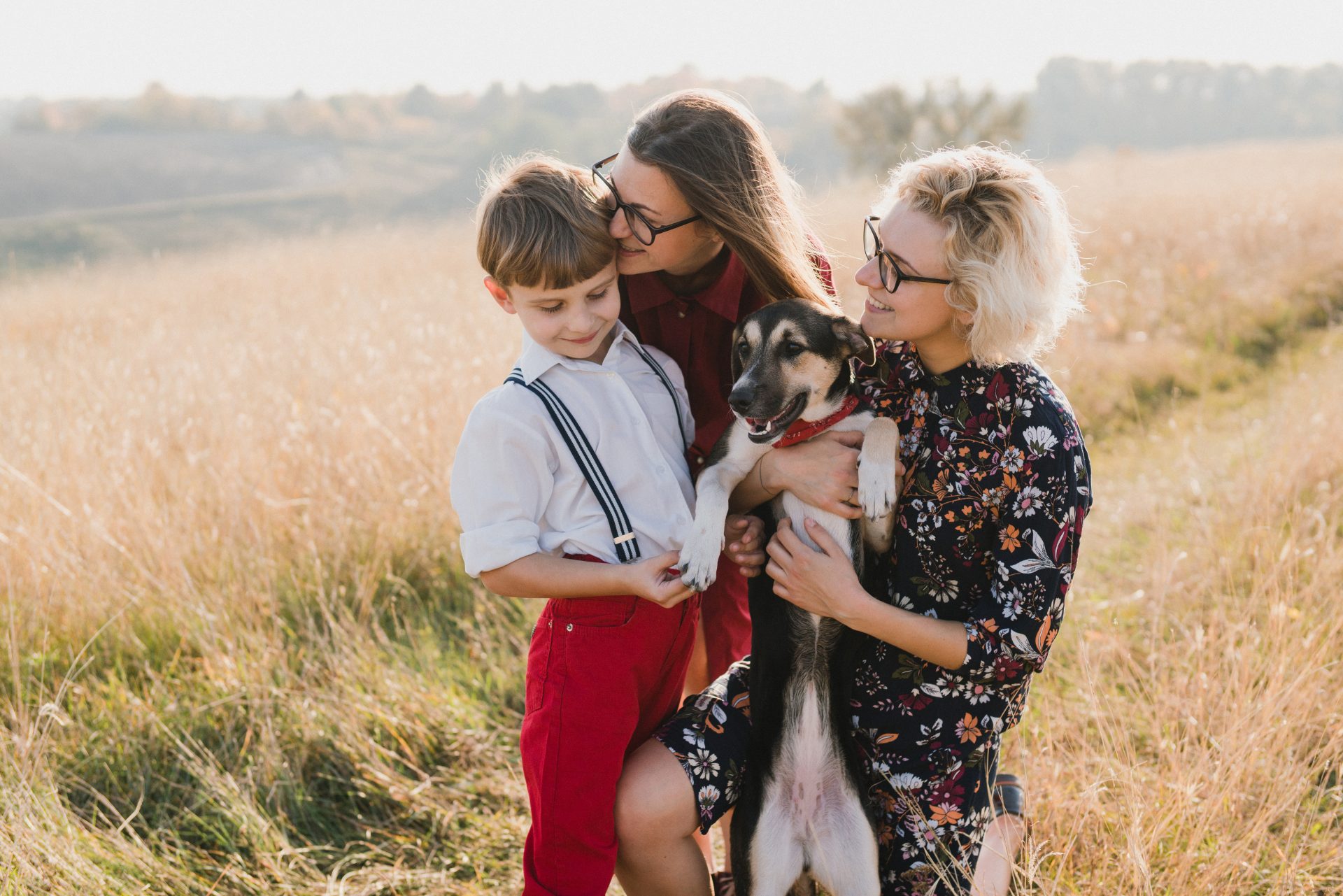 two women in a photoshoot with their child and dog two women in a photoshoot with their child and dog